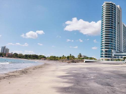 a view of a beach with a tall building at Fantastic Beach condo with pool and mountain views in Nueva Gorgona