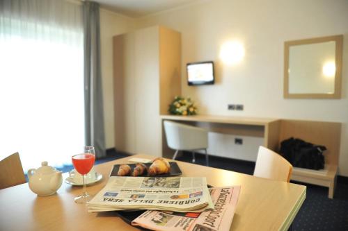 a newspaper sitting on top of a table with a newspaper at Palace Hotel Zingonia in Verdellino