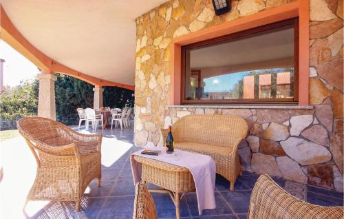 a patio with a table and chairs and a stone wall at Beach Front Home In Ca- With Wifi in Monte Nai
