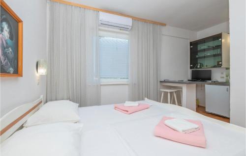 1 dormitorio blanco con 2 toallas rosas en una cama en Amazing Apartment In Stari Grad With Kitchen, en Stari Grad