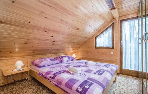 ein Schlafzimmer mit einem Bett in einer Holzhütte in der Unterkunft Lovely Home In Vrbovsko With Kitchen in Jablan