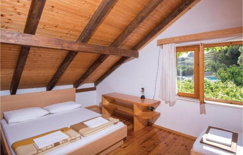 1 dormitorio con cama, escritorio y ventana en Beautiful Home In Podobuce With Kitchen en Podobuče
