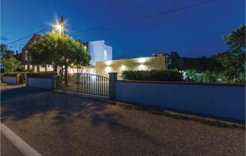 a fence in front of a building with a street at Two-Bedroom Apartment In Verunic in Verunić