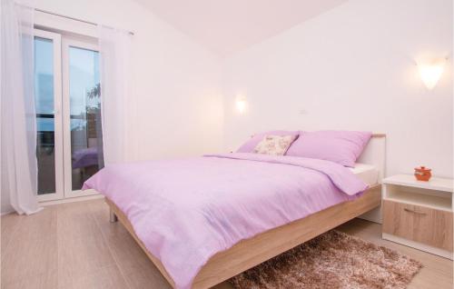 a white bedroom with a bed and a window at Two-Bedroom Apartment In Verunic in Verunić
