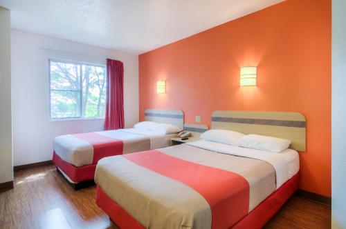 2 camas en una habitación con paredes de color naranja en Motel 6-Joliet, IL - Chicago - I-55, en Joliet