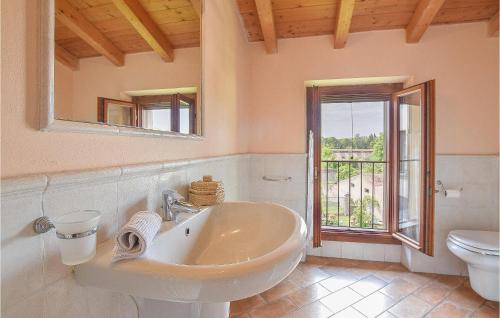 bagno con lavandino, servizi igienici e finestra di Casa Nel Borgo a Monzambano