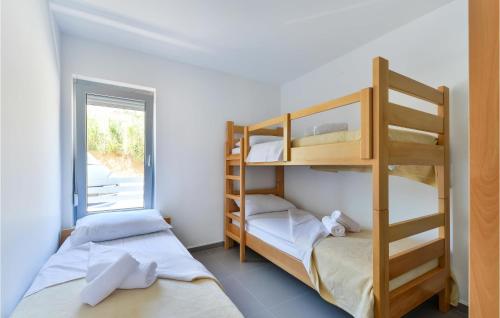 2 Etagenbetten in einem Zimmer mit Fenster in der Unterkunft Amazing Apartment In Pag With Wifi in Pag