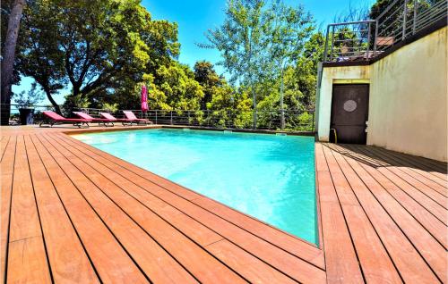 a large swimming pool with a wooden deck at Amazing Home In Sauveterre With Wifi in Sauveterre
