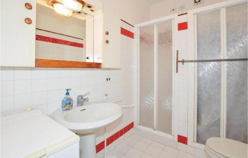 uma casa de banho branca com um lavatório e um chuveiro em Casa Daniela em Punta Ala