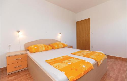 a bedroom with a large bed with orange pillows at Beautiful Apartment In Krvavica With Wifi in Krvavica