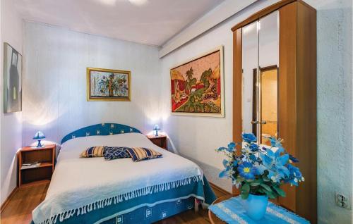 ein Schlafzimmer mit einem blauen Bett und einer Vase aus Blumen in der Unterkunft Stunning Apartment In Novigrad With Wifi in Novigrad Istria