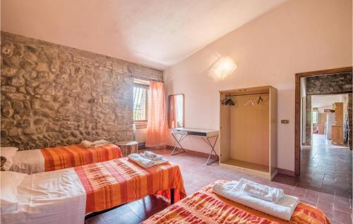 a room with two beds and a stone wall at Materno 4 in Radicondoli