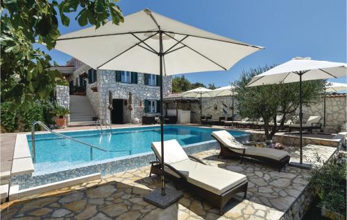 a pool with two chairs and an umbrella next to it at Gorgeous Home In Razanj With Wifi in Ražanj