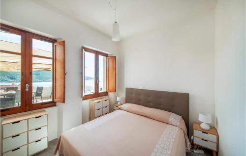 a bedroom with a bed and two windows at La Corsara in Torre Dei Corsari