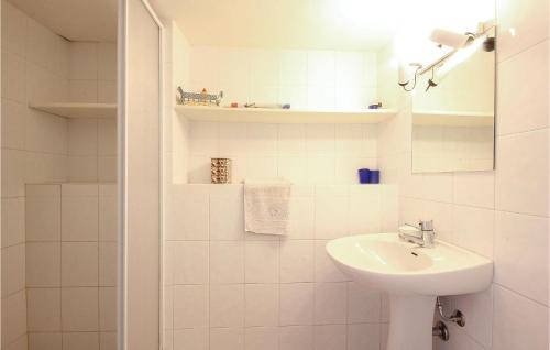 Baño blanco con lavabo y espejo en La Collina en Olbia