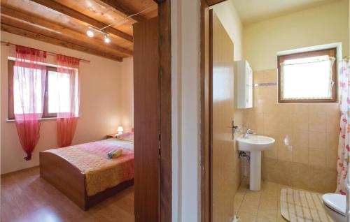 een slaapkamer met een bed en een badkamer met een wastafel bij Awesome Home In Bateli With Wifi in Želiski