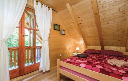 a bedroom with a bed in a log cabin at Beautiful Home In Licki Osik With Kitchen in Lički Osik