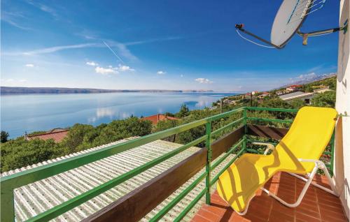 a yellow chair on a balcony with a view of the water at Holiday Home Baric Draga Baric Draga in Barić Draga
