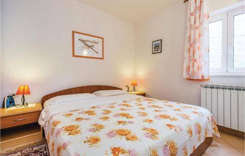 sypialnia z dużym łóżkiem z narzutą kwiatową w obiekcie Lovely Apartment In Moscenicka Draga With Outdoor Swimming Pool w mieście Mošćenička Draga