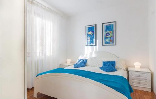 - une chambre blanche avec un lit et des oreillers bleus dans l'établissement Cozy Apartment In Rabac With Wifi, à Rabac