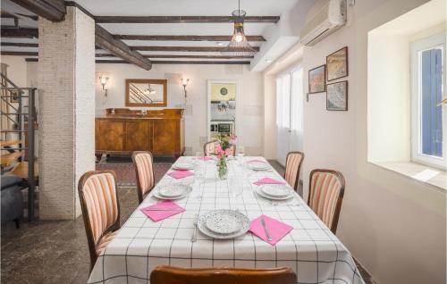 a dining room with a table with pink napkins on it at Four-Bedroom Holiday Home In Vrsar in Vrsar