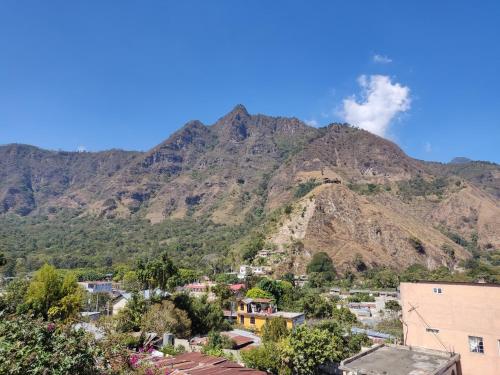 una cittadina di fronte a una montagna con fumo di Hotel Posada Belén a San Juan La Laguna