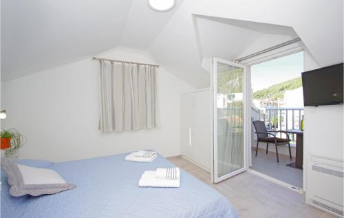 ein Schlafzimmer mit einem blauen Bett und einem Balkon in der Unterkunft Awesome Home In Drvenik With Wifi in Drvenik