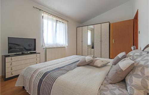 a bedroom with a bed with a dresser and a television at Gorgeous Home In Vodnjan With Kitchen in Vodnjan