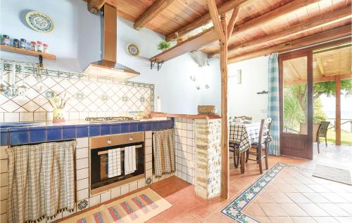 a kitchen with a stove top oven next to a table at Gorgeous Home In Menfi Ag With Wifi in Porto Palo