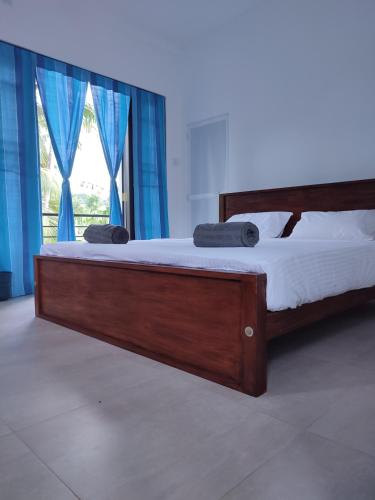 a bed in a room with a large window at Dollyz Home - Sri Lanka in Ambalangoda