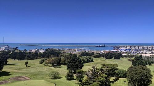 a view of a golf course with the ocean in the background at ESPECTACULAR Alem 5007 piso 7 in Mar del Plata
