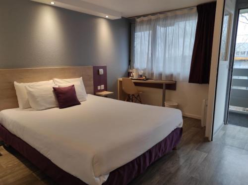 een hotelkamer met een groot bed en een bureau bij Kyriad Meaux Sud Nanteuil Les Meaux in Nanteuil-lès-Meaux