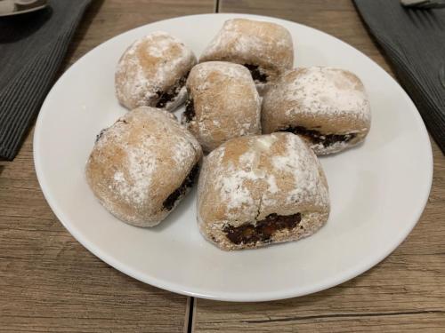 a plate of donuts with powdered sugar on it at B&B D'Amari Affittacamere in Palermo
