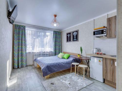 a small bedroom with a bed and a kitchen at YourHouse на Толе би Весновка in Almaty