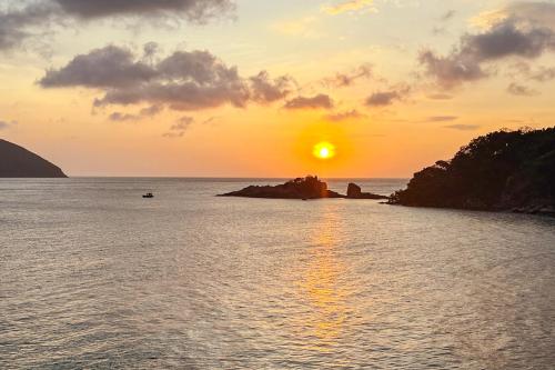 a sunset over a body of water with a island at Eden House & Coffee Con Dao in Con Dao