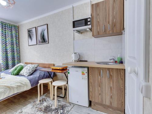 a small kitchen with a bed and a refrigerator at YourHouse на Толе би Весновка in Almaty