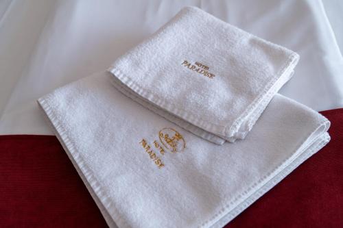 a white napkin sitting on top of a bed at Hotel Paradise in Ognyanovo