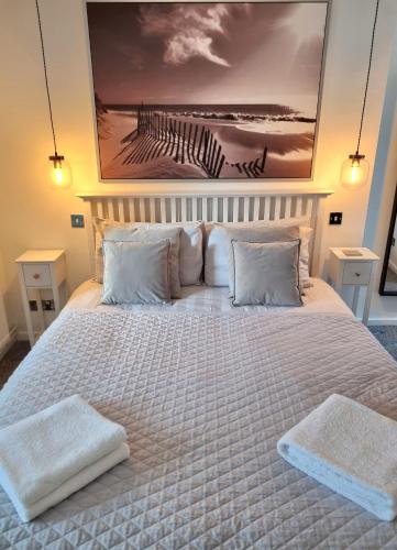 a large white bed with two towels on it at Goldsmith in Southampton