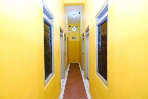 an empty hallway of a building with yellow walls at OYO Life 2867 Kos Kuning in Solo
