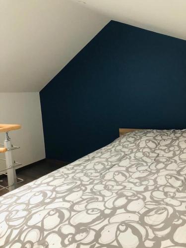 une chambre avec un lit et un mur bleu dans l'établissement Charmette, à Dijon