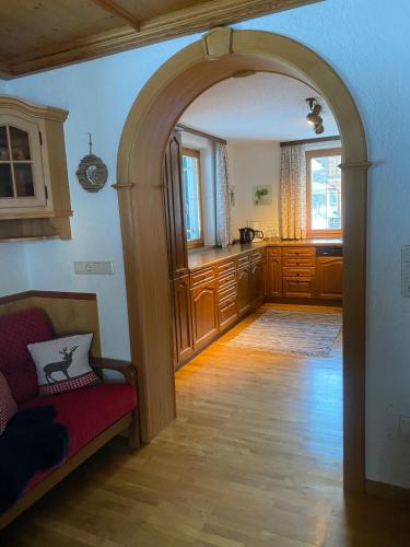 an archway in a room with a couch and a kitchen at Ahnenhöfl in Partenen