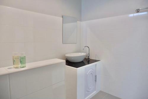 a white bathroom with a white sink and a sink at โรงแรมคอมม่อนเวลธ์ Commonwealth Hotel&Resort in Suan Phung