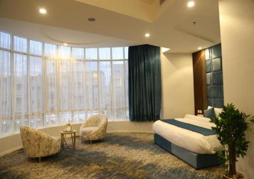 a hotel room with a bed and a large window at Areen Hotel Airport in Jeddah
