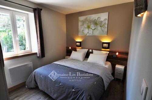 a bedroom with a bed and a painting on the wall at Domaine Les Bastidons in Gordes