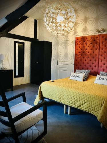 une chambre avec un grand lit et un lustre dans l'établissement L'Atrium, à Béthune