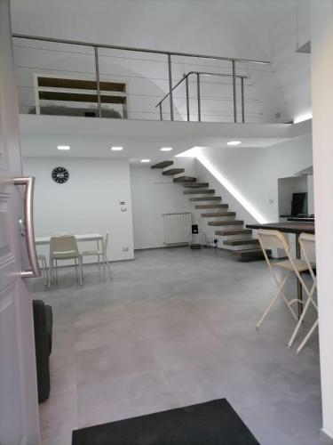 una habitación vacía con escaleras, mesas y sillas en Darsena Apartments, en Molfetta