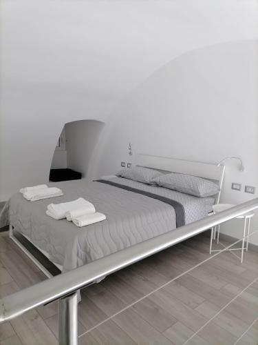 un letto in una camera bianca con asciugamani di Darsena Apartments a Molfetta