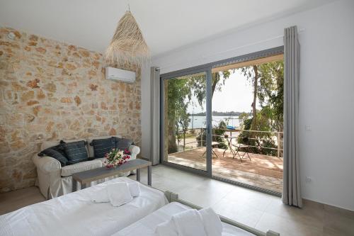 een woonkamer met een bank en een groot raam bij Marina Vista Luxury Studio suites Beach front in Corfu-stad