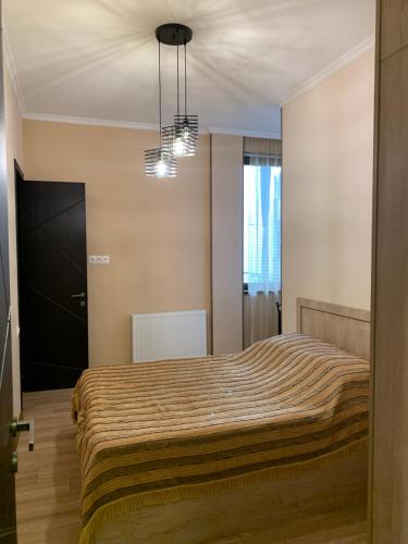 a bedroom with a bed and a chandelier at Melikishvili str. apartment in Tbilisi City