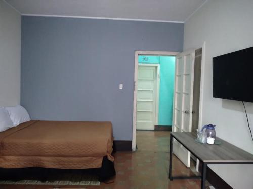 a bedroom with a bed and a flat screen tv at Hotel Mayesstic in Guatemala